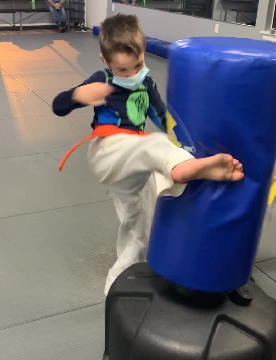 A young student kicking a standing bag at Giroux Bros