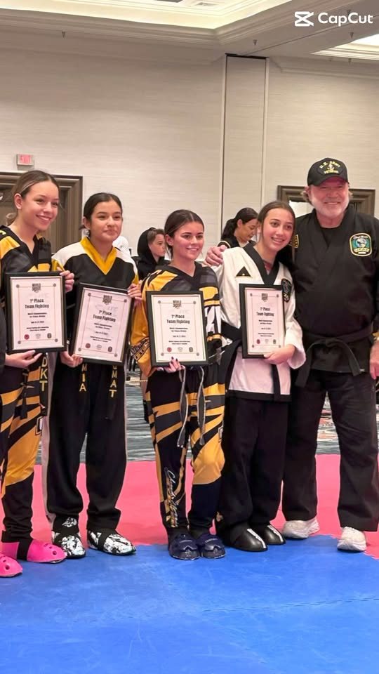 Giroux Bros students holding first-place certificates beside their instructor at a tournament